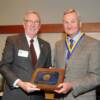 Colin Hunt accepting inductee plaque and medallion for father-in-law Holger Hoiriis.